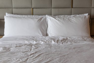Otel odasındaki rahat ve temiz beyaz çarşaf.