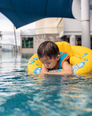 1-2 yaşlarındaki çocuk portresi. Oda penceresinden dışarı bakan sağlık maskeli çocuk.