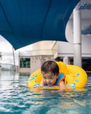 1-2 yaşlarındaki çocuk portresi. Oda penceresinden dışarı bakan sağlık maskeli çocuk.