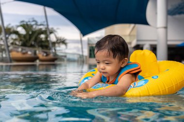 1-2 yaşlarındaki çocuk portresi. Oda penceresinden dışarı bakan sağlık maskeli çocuk.