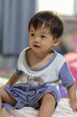 Kafasından vurulan Asyalı Çinli bir çocuğun mutlu ve sakin yüzü..