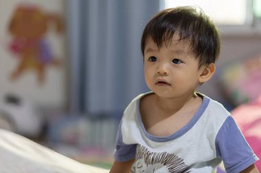 Kafasından vurulan Asyalı Çinli bir çocuğun mutlu ve sakin yüzü..