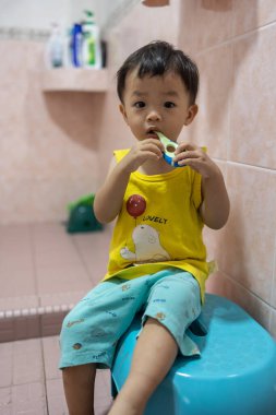 Asyalı çocuk diş fırçalamayı öğreniyor.