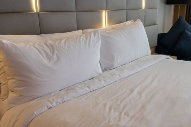 Otel odasındaki rahat ve temiz beyaz çarşaf.
