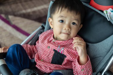 2 yaşındaki sevimli bir çocuğun havalimanında bebek arabasında otururken saf mutlulukla çekilmiş yürek ısıtan bir portresi.