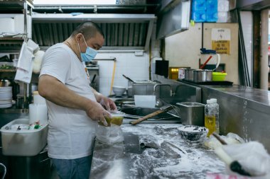 Singapur - 13 Kasım 2022: Singapur 'daki Boon Keng Hawker Center' ın hareketli sahneleri günlük anların ve lezzetlerin zengin duvar halılarını yakalıyor.