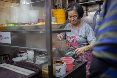 Singapur - 13 Kasım 2022: Singapur 'daki Boon Keng Hawker Center' ın hareketli sahneleri günlük anların ve lezzetlerin zengin duvar halılarını yakalıyor.