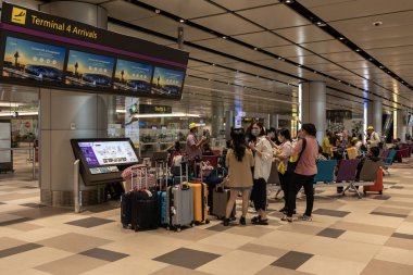 Singapur - 09 Kasım 2022: Ziyaretçiler Changi Havalimanı 'ndaki Kalkış Salonu' nda yürüyorlar. Asya 'nın en büyük ulaşım merkezlerinden biri olan 5 yolcu terminali bulunmaktadır ve 100' den fazla havayolu hizmet vermektedir..