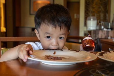 Çocuk mutlu, kek yiyor.