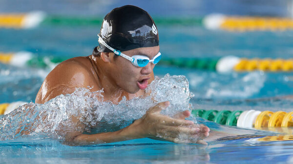 Кота-Кинабалу, Сабах, Малайзия - 06 января 2023 года: Неопознанный пловец-подросток плавает в бассейне в Кота-Кинабалу, Сабах, Малайзия