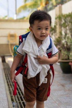 Mutlu 2-3 yaşlarındaki portre resmi okul çantasını mutlu bir şekilde taşıyor.