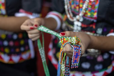 Close-up image of a woman hand holding a gift from Kadazandusun ethnic wearing traditional costumes during Kaamatan Festival at KDCA Penampang,Sabah, Malaysia clipart