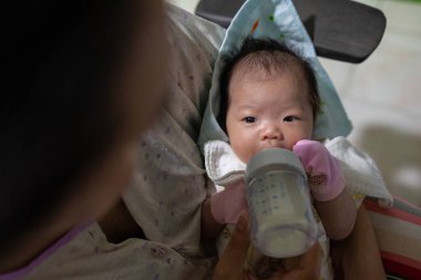 Asyalı bebek sütü şişeden içer, süt zamanı, yatağa git.