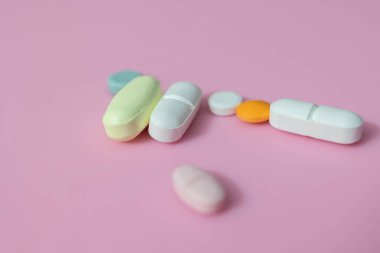 hap kapsülleri ve tabletler pembe arka planda izole