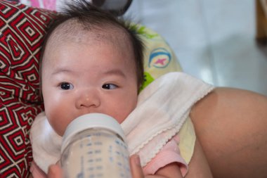 Asyalı bebek sütü şişeden içer, süt zamanı, yatağa git.