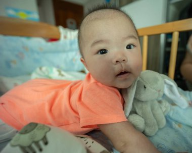 Mutlu yerel yaşam tarzının portresi bebek yatağında Asyalı Çinli bir kız bebek