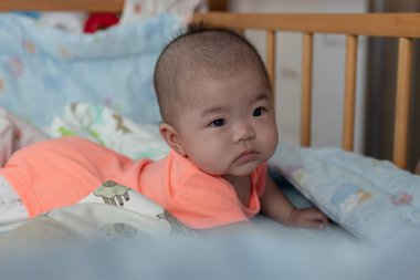 Mutlu yerel yaşam tarzının portresi bebek yatağında Asyalı Çinli bir kız bebek