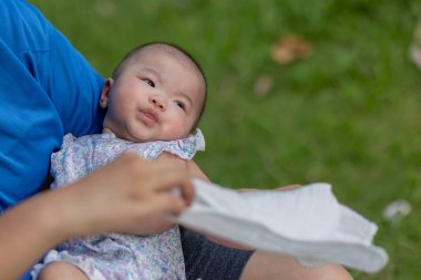 Sevgili anne ve yeni doğmuş bebeği akşam vakti açık hava parkında kollarında.
