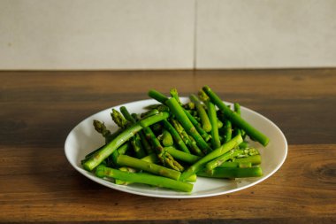Beyaz bir tabakta kuşkonmaz hazır. Yemeye hazır. Vücut için sağlıklı yiyecek, antioksidan kaynağı..