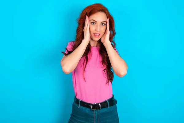 Jonge Blanke Roodharige Vrouw Draagt Roze Shirt Blauwe Achtergrond Aangenaam — Stockfoto