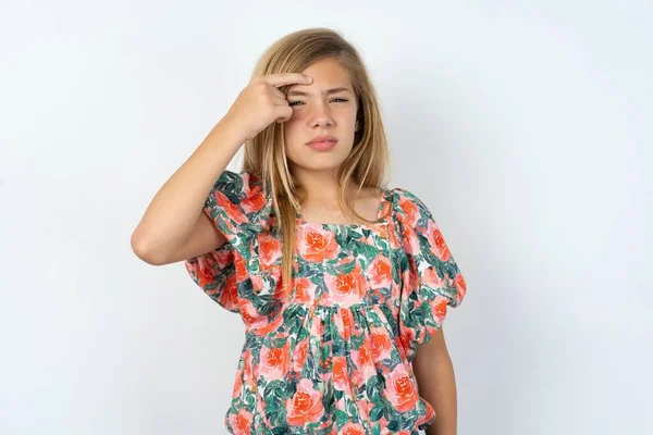 美しい10代の女の子が白いスタジオの背景に花のTシャツを着て額ににきび 黒い頭の感染症で不幸な指しています スキンケアのコンセプト — ストック写真
