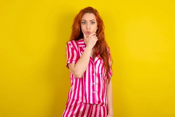 Sarı Arka Planda Pembe Pijama Giyen Genç Kızıl Saçlı Kadın — Stok fotoğraf