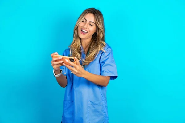 Νεαρή Όμορφη Γιατρός Γυναίκα Στέκεται Πάνω Από Μπλε Φόντο Στούντιο — Φωτογραφία Αρχείου