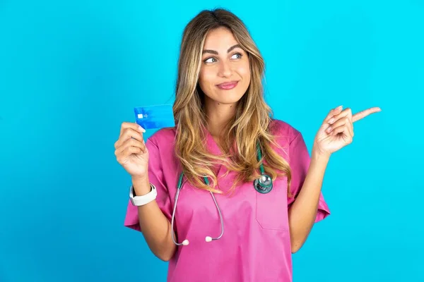 Curiosa Sonriente Joven Hermosa Doctora Pie Sobre Fondo Estudio Azul —  Fotos de Stock