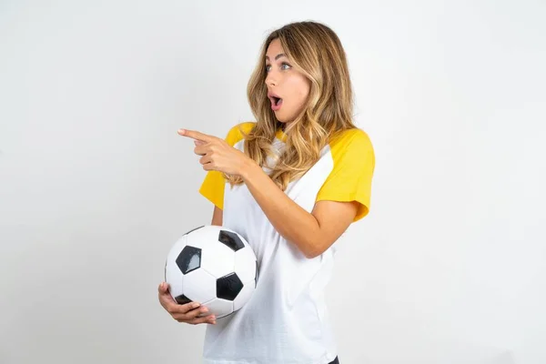 Joven Mujer Hermosa Aturdida Usando Camiseta Fútbol Sobre Fondo Blanco — Foto de Stock