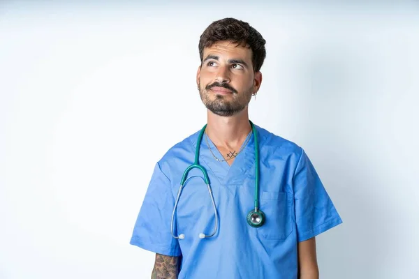 Bonito Enfermeira Homem Vestindo Cirurgião Uniforme Sobre Isolado Fundo Olhando — Fotografia de Stock