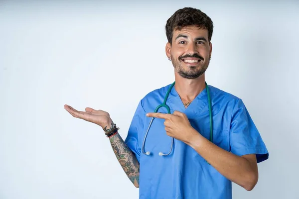 Bonito Enfermeira Homem Vestindo Cirurgião Uniforme Sobre Branco Fundo Apontando — Fotografia de Stock