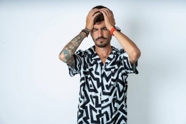 Yazlık gömlekli bir adam izole edilmiş beyaz arka plan üzerinde duruyor. Aşırı çalışmaktan dolayı baş ağrısı ve stresten muzdarip. Depresyon ve acı kavramı.