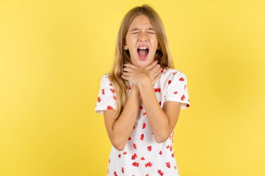 caucasian kid girl wearing polka dot shirt over yellow background shouting suffocate because painful strangle. Health problem. Asphyxiate and suicide concept. clipart