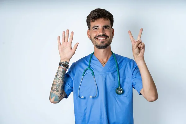 Schöner Krankenpfleger Der Chirurgenuniform Über Weißem Hintergrund Trägt Und Mit — Stockfoto