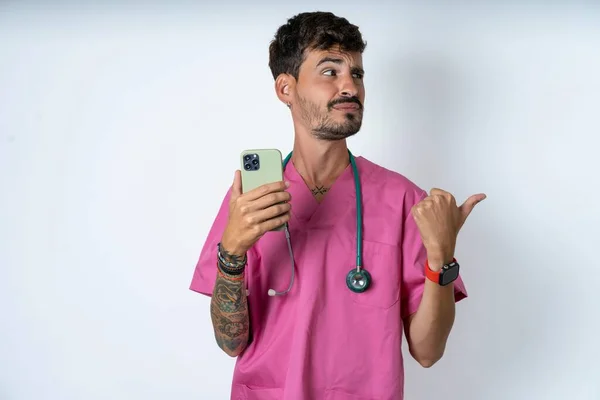 Knappe Verpleegkundige Man Draagt Chirurg Uniform Witte Achtergrond Punten Duim — Stockfoto