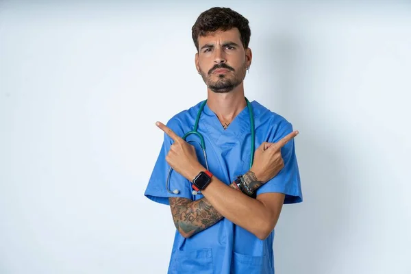 Ernstige Knappe Verpleegkundige Man Draagt Chirurg Uniform Witte Achtergrond Kruist — Stockfoto