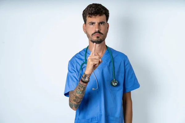 Knappe Verpleegkundige Man Dragen Chirurg Uniform Witte Achtergrond Gefrustreerd Wijzen — Stockfoto