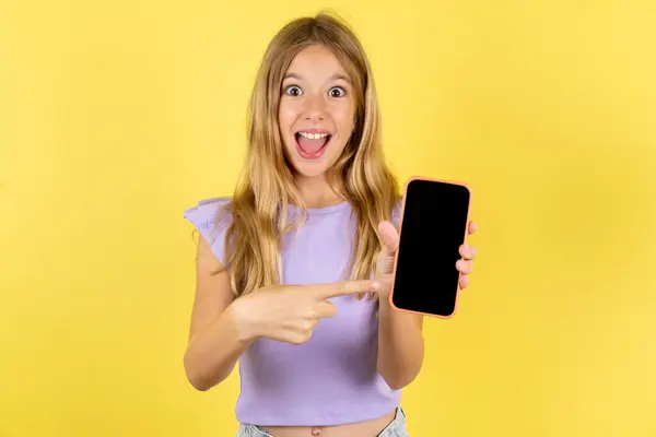 Attractive Cheerful Blonde Girl Wearing Violet Shirt Yellow Background Holding — Stock Photo, Image