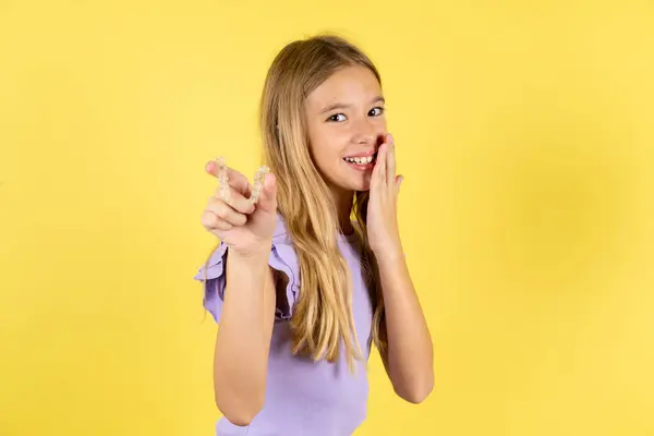 Gelukkig Blond Meisje Draagt Violet Shirt Gele Achtergrond Houden Tonen — Stockfoto