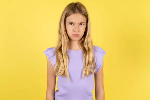 Ofendida Menina Loira Insatisfeita Vestindo Camiseta Violeta Sobre Fundo Amarelo — Fotografia de Stock