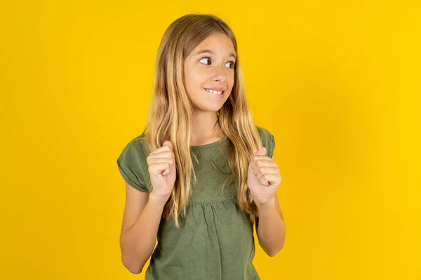 Blond Little Girl Wearing Khaki Blouse Yellow Background Clenches Fists — Stock Photo, Image