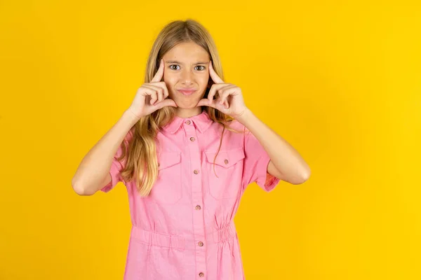 Serious Concentrated Girl Wearing Pink Jacket Yellow Background Keeps Fingers — Stock Photo, Image