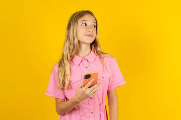 Mädchen Rosa Jacke Über Gelbem Hintergrund Hält Mobiltelefone Der Hand — Stockfoto