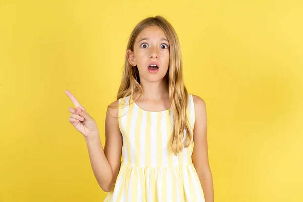 Емоційна Дівчина Жовтій Сукні Жовтому Тлі Тримає Щелепу Від Шоку — стокове фото