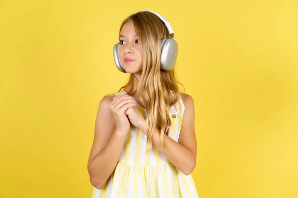 Girl Wearing Yellow Dress Yellow Background Wears Stereo Headphones Listening — Stock Photo, Image