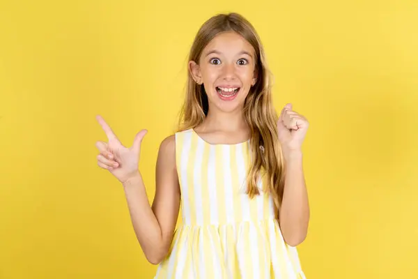Girl Wearing Yellow Dress Yellow Background Points Empty Space Holding — Stock Photo, Image