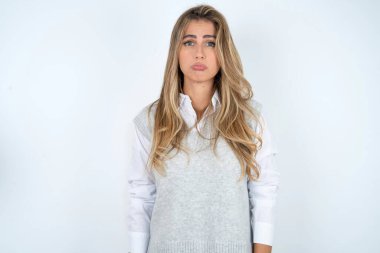 Kasvetli, reddedilmiş güzel İspanyol iş kadını beyaz arka planda sorunlar ve zorluklar yaşıyor, alt dudağını kıvırıyor ve umutsuzluk içinde gözlerini kapatıyor, depresyonda.