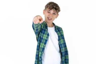 Beyaz arka planda ekose gömlekli yakışıklı bir çocuk. Kameraya kızgın ve sinirli bir şekilde seninle kavga etmeye hazır olduğunu gösteriyor..