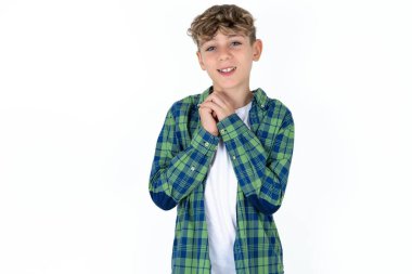 Beyaz arka planda ekose gömlek giyen yakışıklı genç çocuk mutlu bir şekilde gülümsüyor, müfettişten hoş haberler aldığına seviniyor, el ele tutuşuyor. İnsan duyguları kavramı.