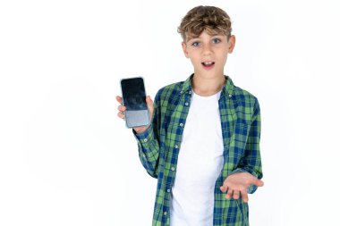 Ekose gömlekli, beyaz arka plan ve cep telefonu olan yakışıklı bir çocuk. Akıllı telefonu sunuyorum. Reklam kavramı.
